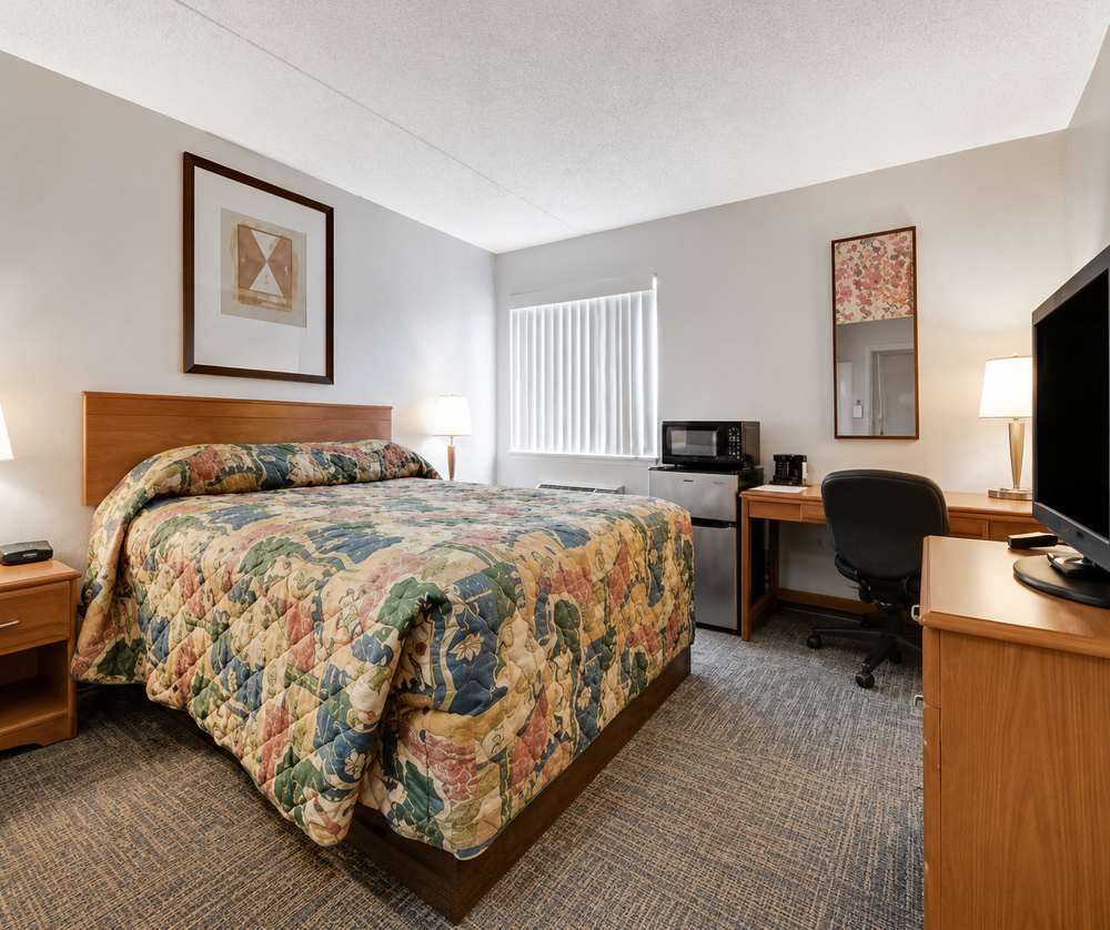 Queen guest room with desk and television